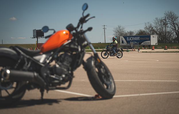 Close up of a motorcycle with a rider in the background